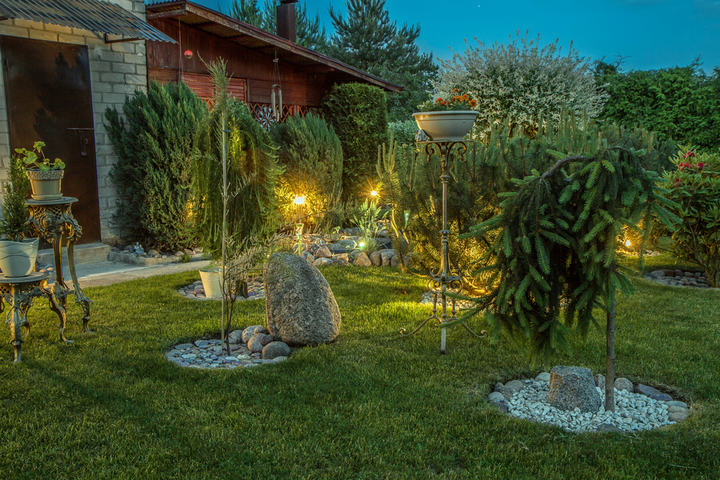 Private garden in the evening, illuminated by lamps