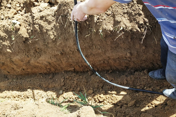 Laying an electric cable in the land.