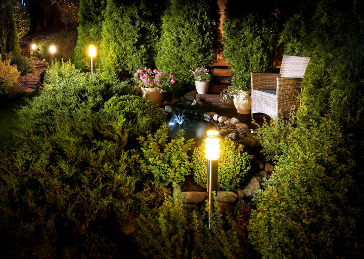 Lighted garden in the evening with lantern lamps