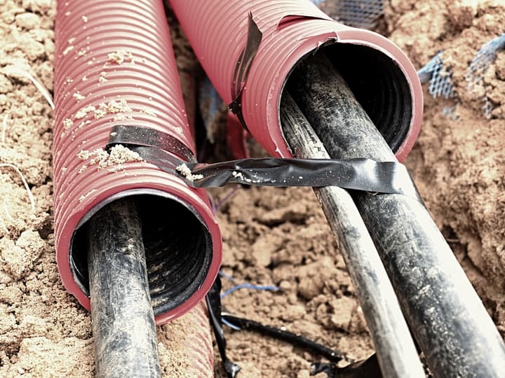 Excavation of trench with black cables