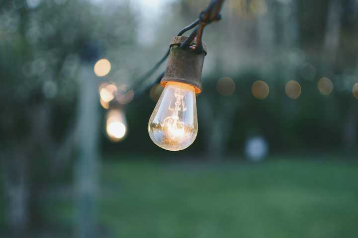 Bright light bulb of outdoor string light hanging in the garden