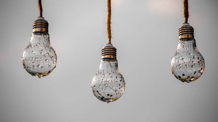 three hanging patio light bulbs covered in water drops