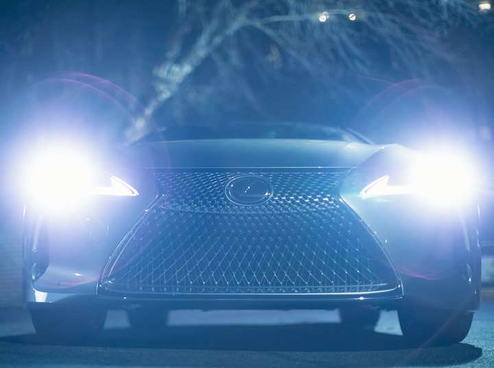 front view of Lexus car with lighted white headlights