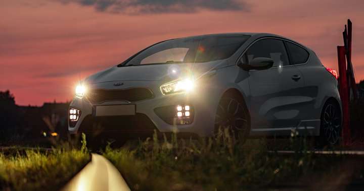 Parked car during the sunset with lighted headlights