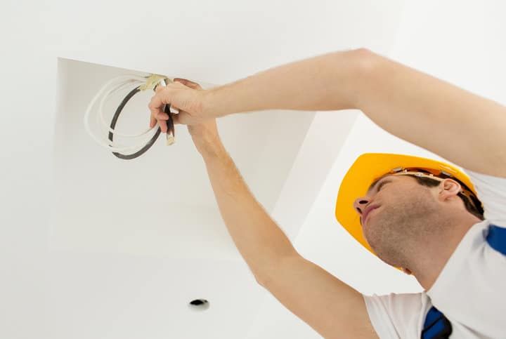 close up of builder or electrician running wires indoors