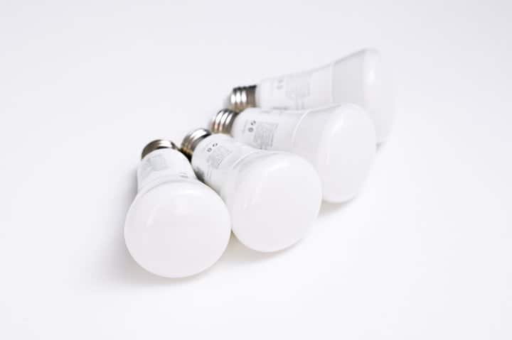 four white smart bulbs on white background