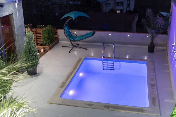 the square shaped pool with violet lighting