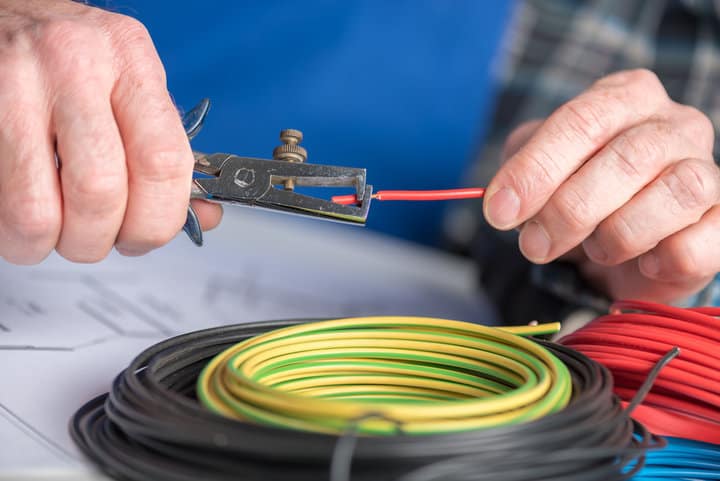 Electrician hands stripping a wire