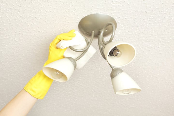  ceiling light fittings with a woman's hand cleaning them