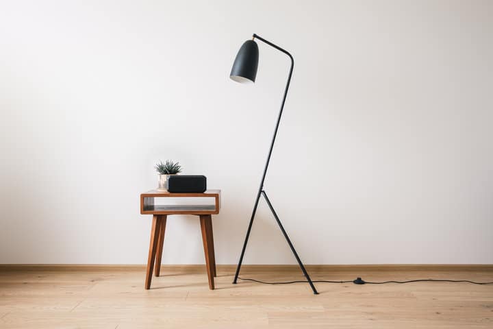 floor lamp next to a table with a cord running on the floor