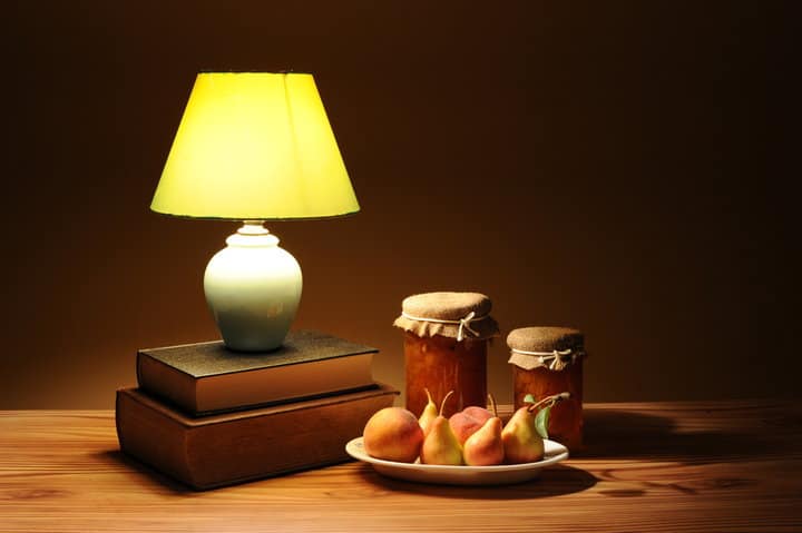 table lamp on books with fruits next to it