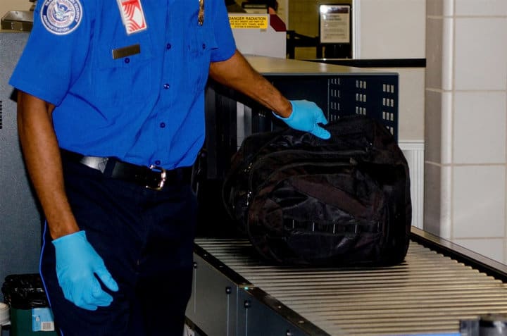 TSA handling luggage